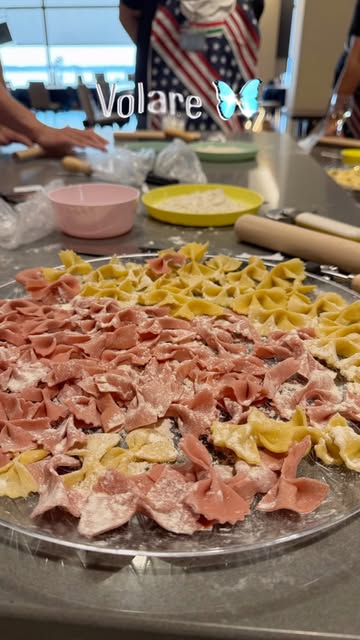 Colorful pink and yellow farfalle pasta laid out on a table during a Sketch of Italy pasta-making class